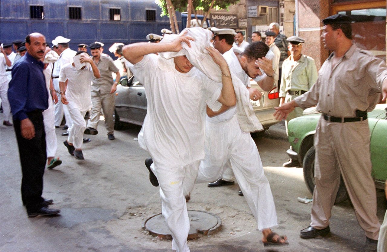 About 50 men accused of breaking laws covering obscenity and public morality cover their faces as they enter a state security court for their trial in Cairo, Egypt in July, 2001. 