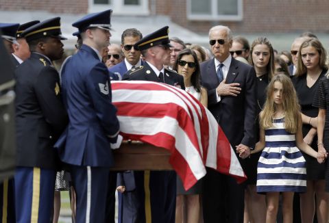 Vice President Joe Biden, accompanied by his family, holds his hand over his heart as he watches an honor guard carry a casket containing the remains of his son into St. Anthony of Padua Roman Catholic Church in Wilmington, on June 6. Standing alongside the vice president are Beau Biden's widow Hallie Biden, left, and daughter, Natalie. 