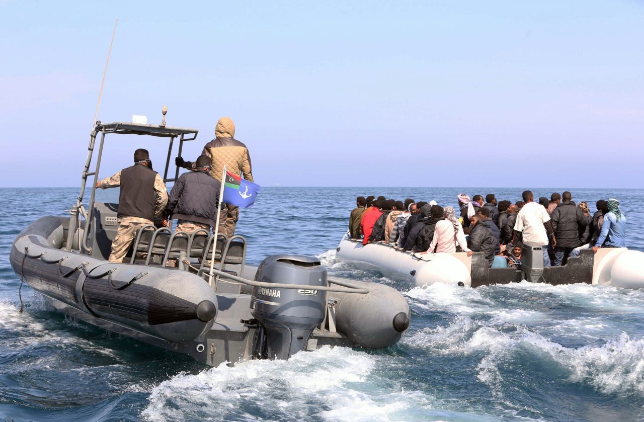 Libyan coast guard members escort a boat carrying migrants, who had hoped to set off to Europe with the help of smugglers, from the coastal town of Garabulli, Libya, on June 6. 