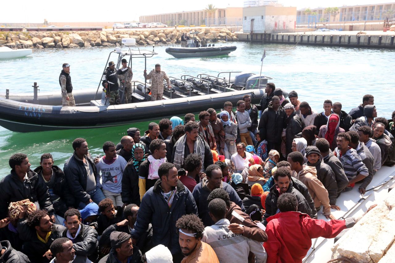 Libyan coast guard personnel watch over migrants after the Libyan navy escorted their vessel to the capital, Tripoli, on June 6. 