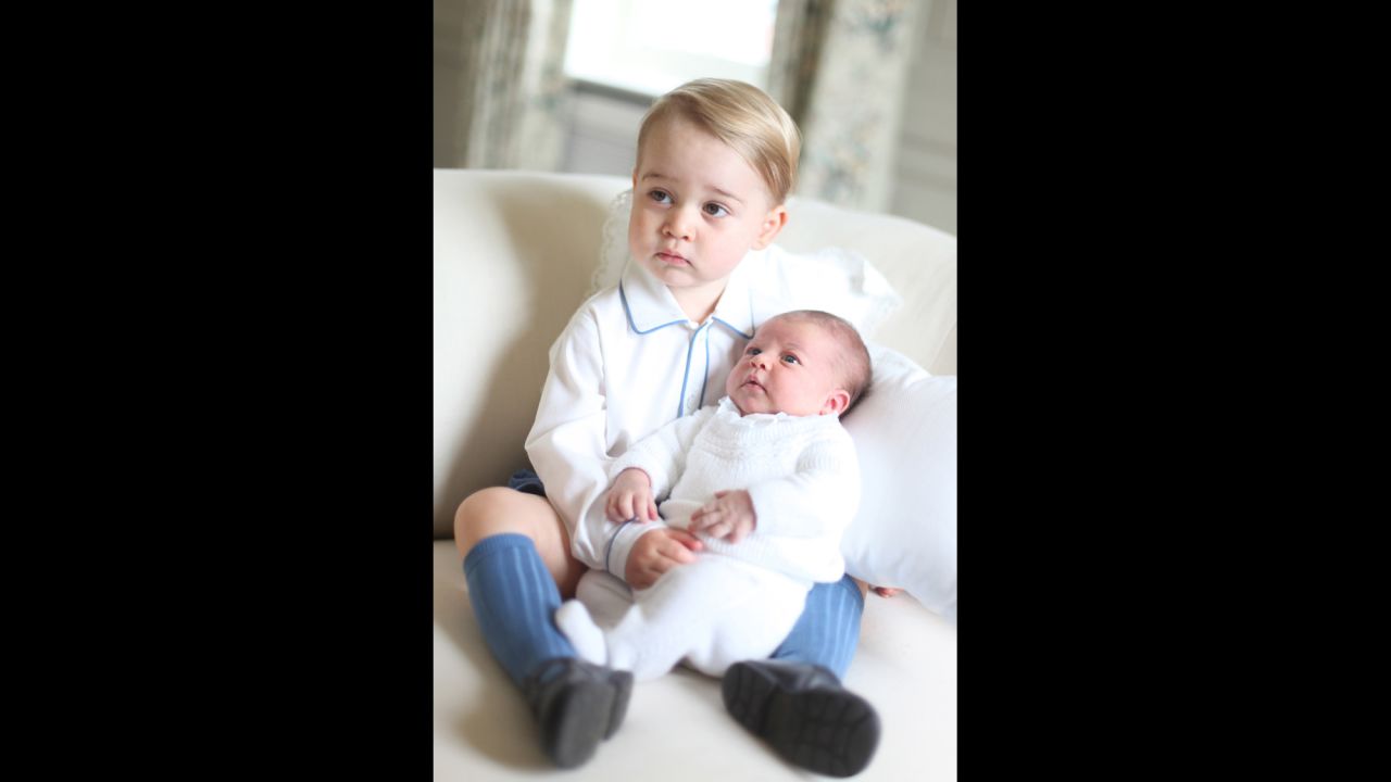 George holds his baby sister, who was only a couple weeks old when photographed. The release of the images comes a day after the palace announced that Charlotte, who's fourth in line to the throne, would be christened on July 5.