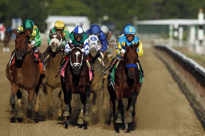 American Pharoah leads Materiality and the rest of the field down the backstretch.