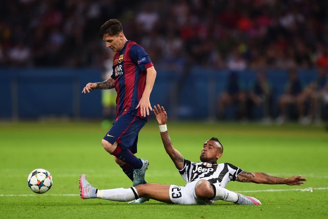 Lionel Messi rides a tackle from Arturo Vidal. The Chilean's tough tackling style earned him an early yellow card.