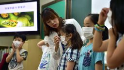 South Korean school students put on face masks during a special class on MERS virus at an elementary school in Seoul on June 3.