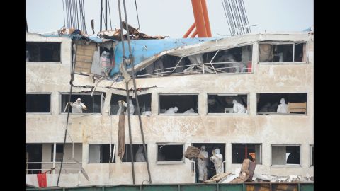 Workers remove debris from the Eastern Star ship on the Yangtze River in China's Hubei province on Sunday, June 7.
