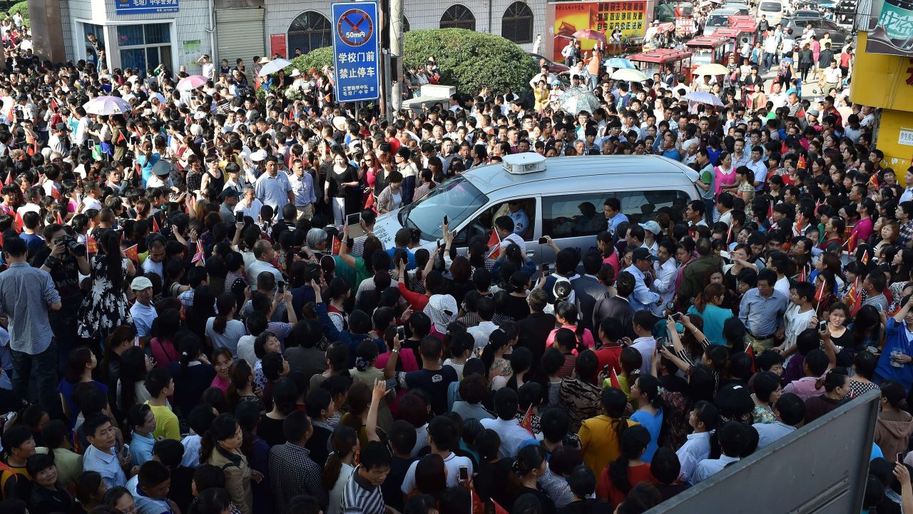 Parents crowd a police car outside Maotanchang High School as students leave to sit the 2015 college entrance exam.