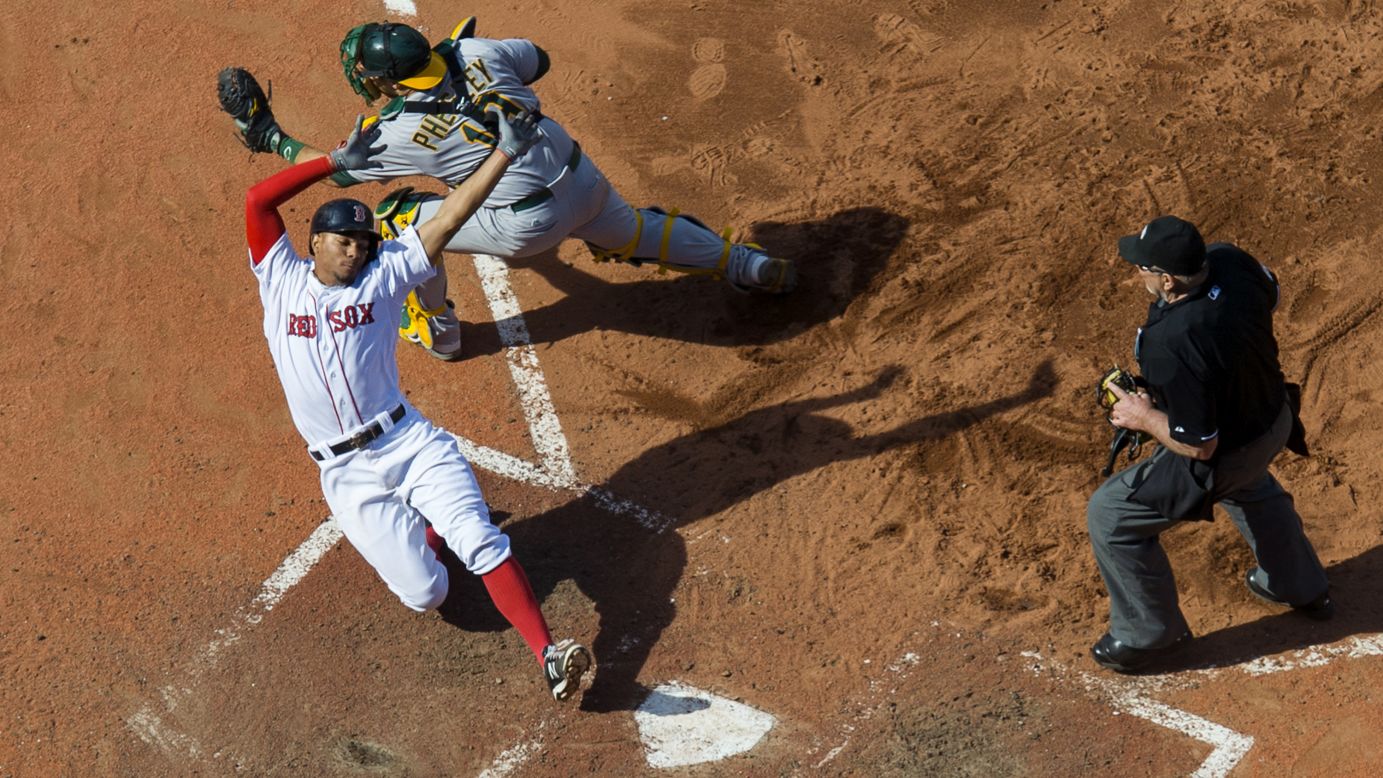 Boston's Xander Bogaerts avoids the tag of Oakland's Josh Phegley during a Major League Baseball game on Sunday, June 7.