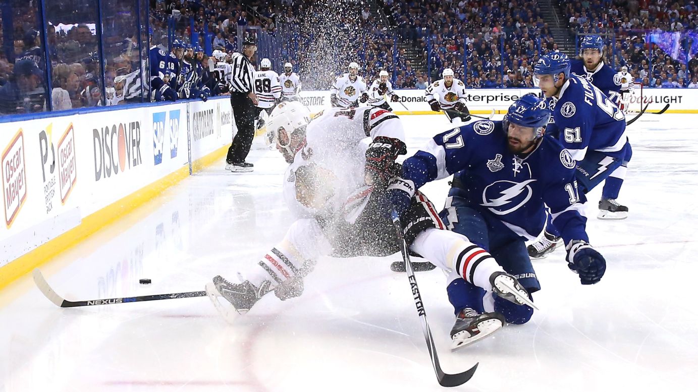 Ice sprays into the air as Tampa Bay's Alex Killorn, right, collides with Chicago's Jonathan Toews during Game 1 of the Stanley Cup Final on Wednesday, June 3.