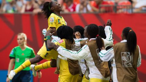 Cameroon's Gabrielle Onguene, left, leaps into the arms of her teammates on the sideline after she scored against Ecuador on June 8. Cameroon won the match 6-0.