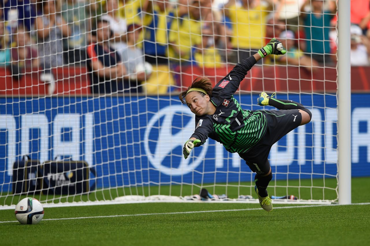 Swiss goalkeeper Gaelle Thalmann dives the right way but can't stop Aya Miyama's penalty shot in the first half.