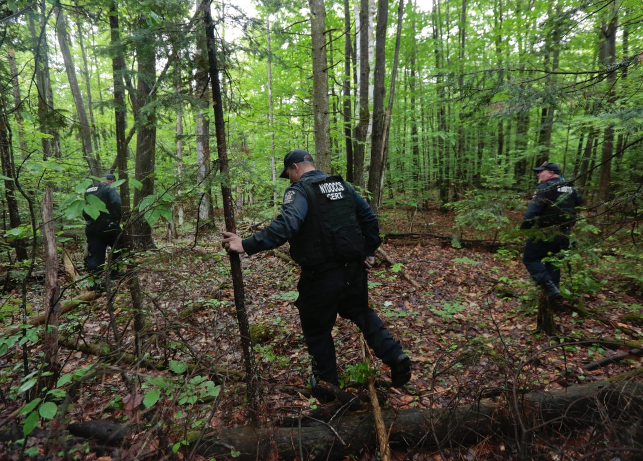 Law enforcement officers search a wooded area in Dannemora on Monday, June 8.