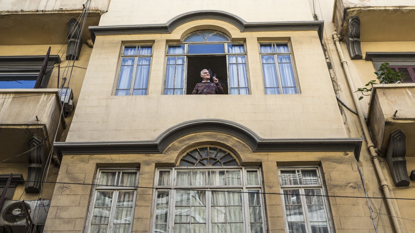 In Beirut, Lebanon, a man smokes a cigarette, surveying the street below. 