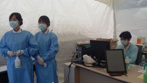 Health care workers wait for patients to treat at a tent outside a Seoul medical facility.