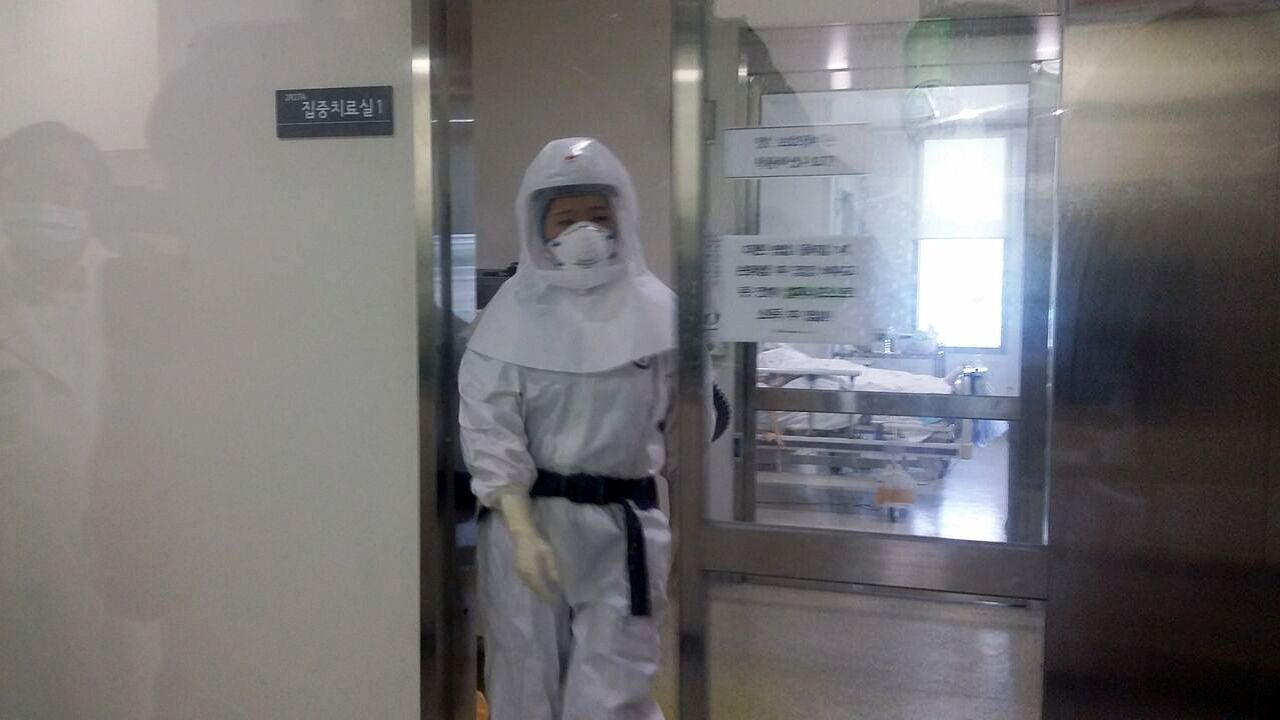 A health care worker in a full hazmat suit exits a patient's room at the Seoul Medical Center where eight people with MERS is being treated.