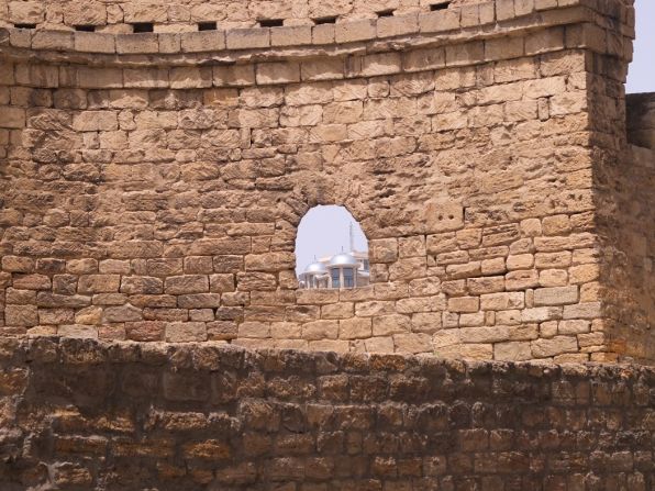 Inside Baku's Old City, a glimpse of new buildings can be seen through an opening in the city walls.