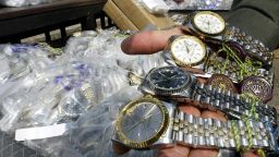 An unidentified Thai customs officer shows counterfeit Rolex watches confiscated in different raids during a display at the customs house in Bangkok, 11 March 2004. Thai authorities displayed different counterfeit items smuggled into the kingdom from overseas to show Thailand's commitment to halting the proliferation of fake goods and violations of intellectual property. AFP PHOTO/ Saeed KHAN (Photo credit should read SAEED KHAN/AFP/Getty Images)