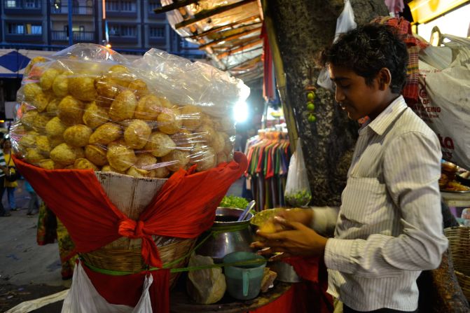 Puchka is the quintessential Kolkata street food. Here, a puchka vendor makes a small hole in the fried dough ball, which is then stuffed with filling and dunked into a tamarind and green mango sauce. 