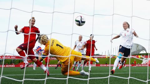 Germany's Anja Mittag, left, scores a goal past Norway goalkeeper Ingrid Hjelmseth during a match in Ottawa on June 11. The final score was 1-1.