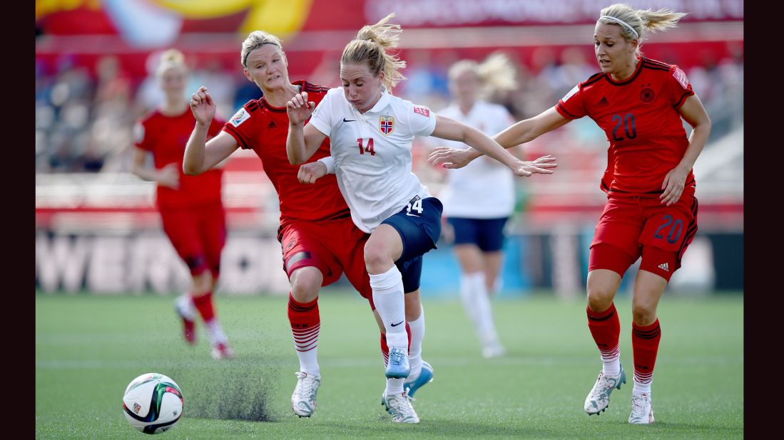 Ingrid Schjelderup of Norway is challenged by two German defenders.