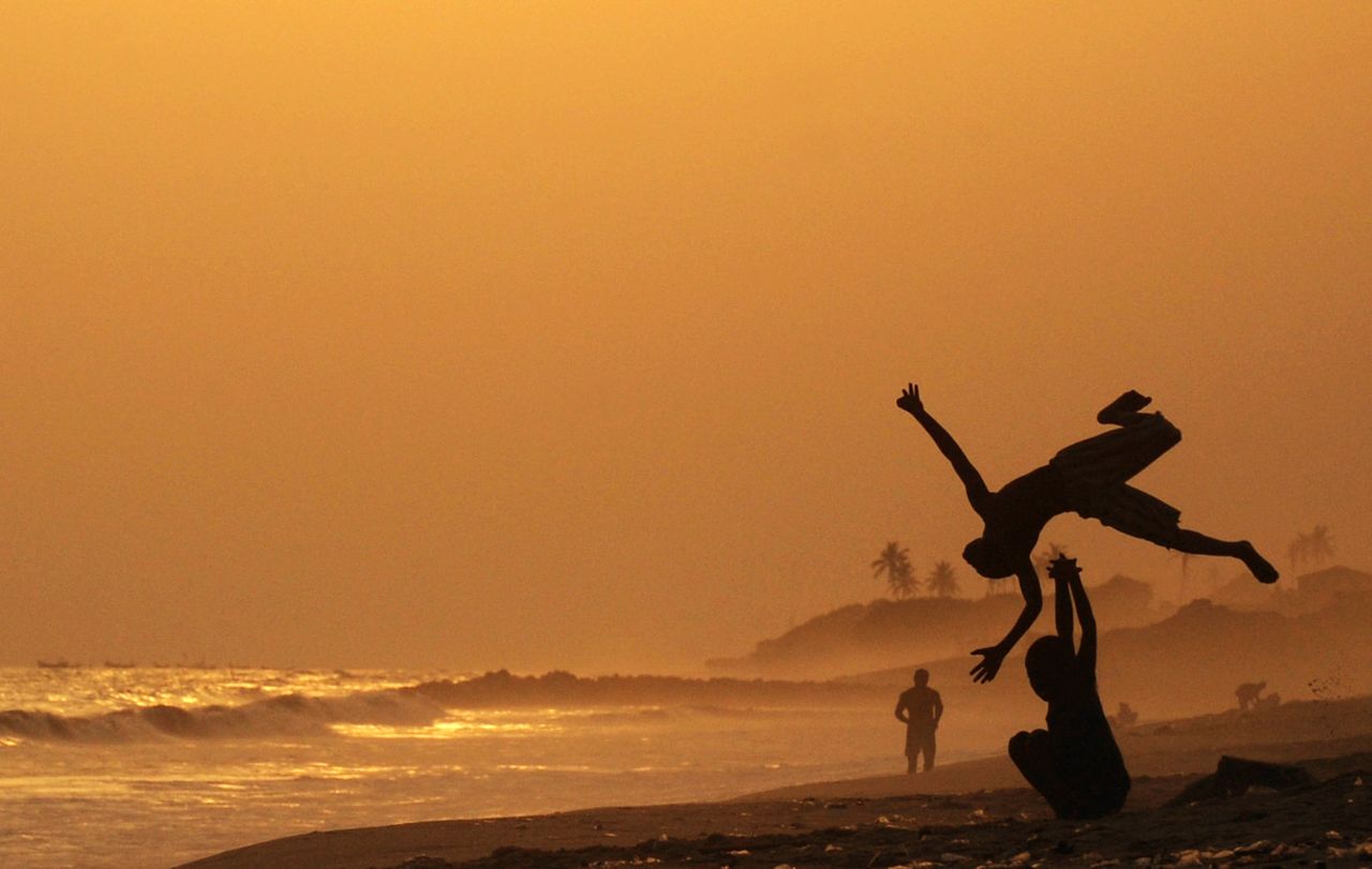 Ghana's capital comes in at number seven, with 528,897 visitors predicted this year. Boys practice somersaults on Accra beach. 