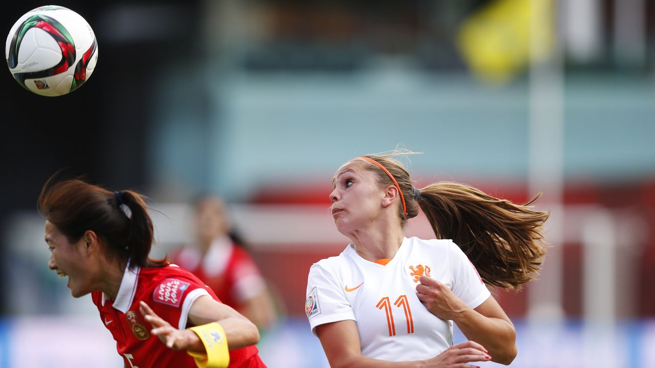 Wu Haiyan of China heads the ball in front of Lieke Martens of the Netherlands. 
