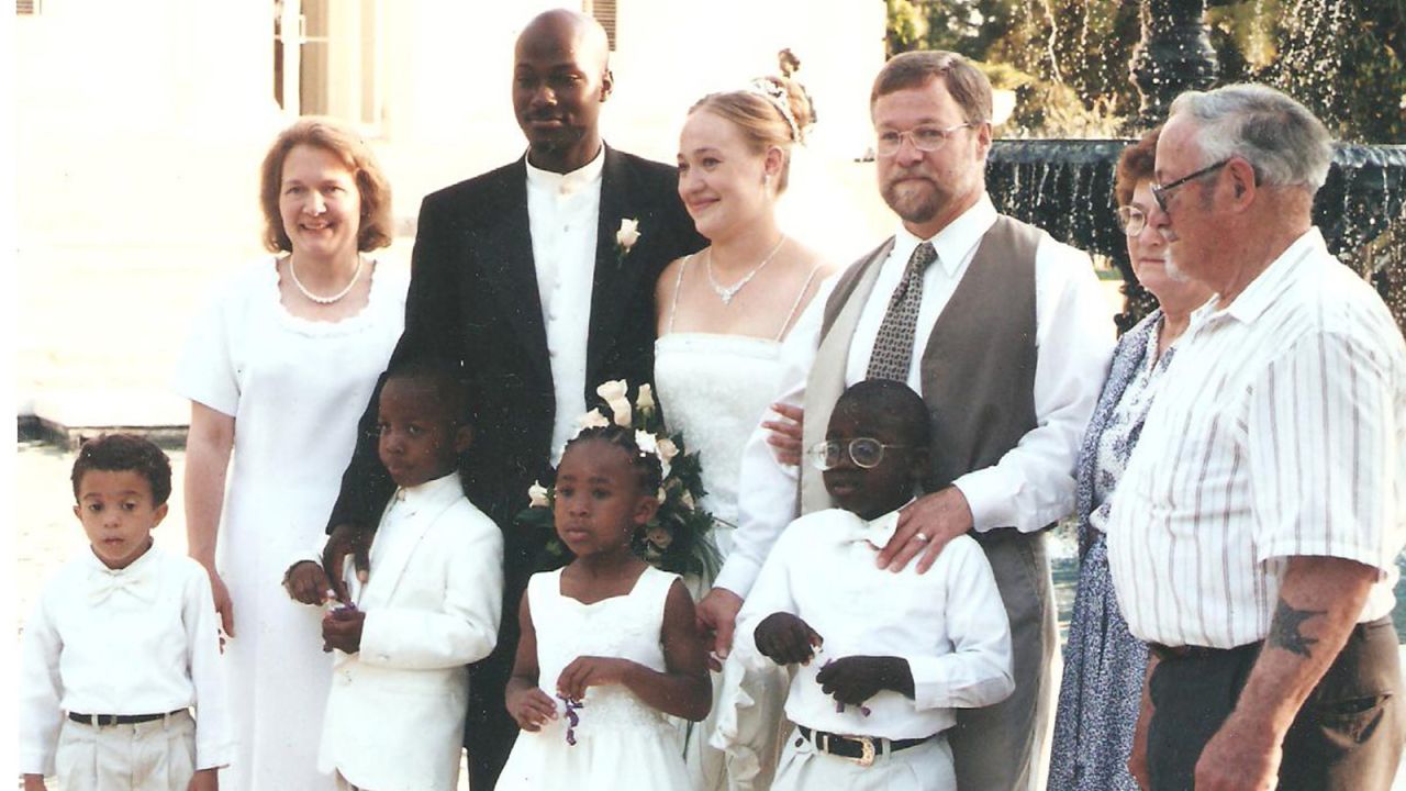 A family photo shows Dolezal's family at her wedding reception in Jackson, Mississippi, on May 21, 2000. Her family is racially mixed; four of her adopted siblings are black. She and her husband, Kevin, are standing between her parents. Her grandparents are at right and her adopted siblings are in the front row.