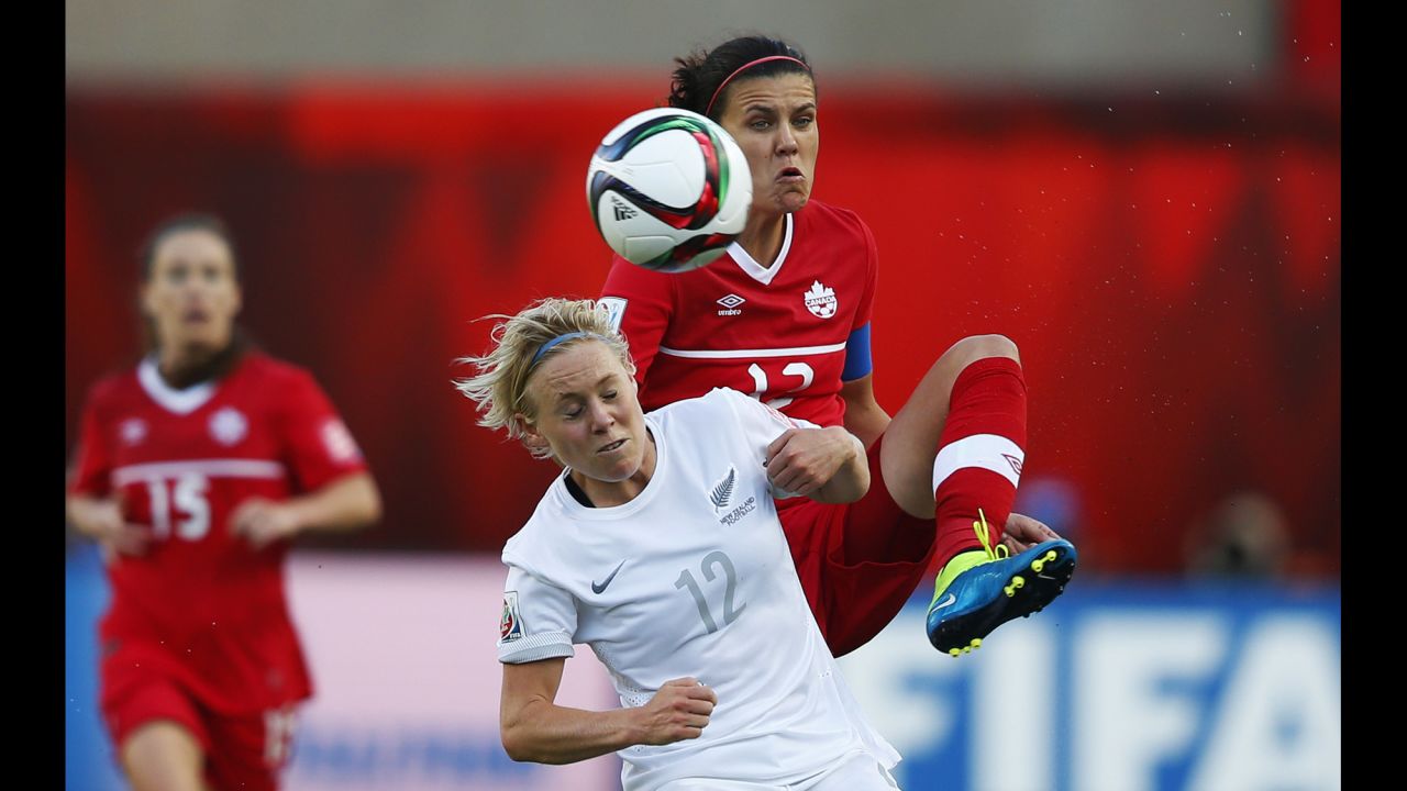 Christine Sinclair of Canada and Betsy Hassett of New Zealand battle for the ball.