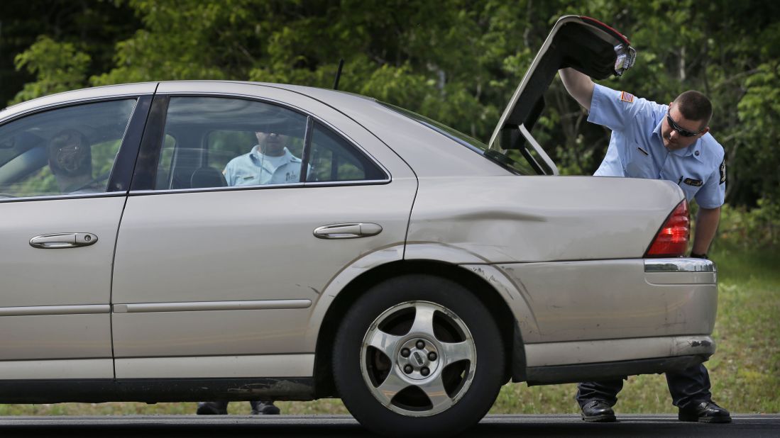 An officer checks the trunk of a car at a checkpoint near the Dannemora border on June 10.