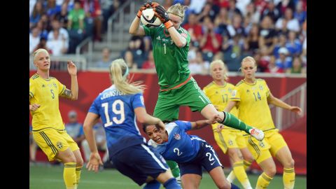 Swedish goalkeeper Hedvig Lindahl leaps over Leroux to catch the ball. 