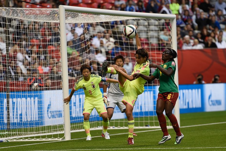 Saki Kumagai of Japan clears under pressure from Francine Zouga of Cameroon.