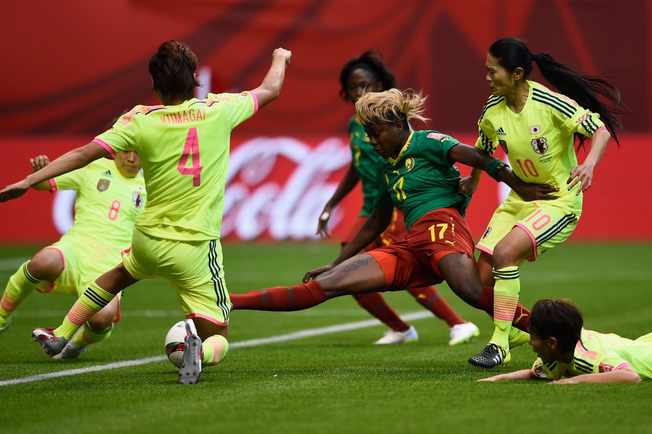 Cameroon's Gaelle Enganamouit is surrounded by Japanese defenders.
