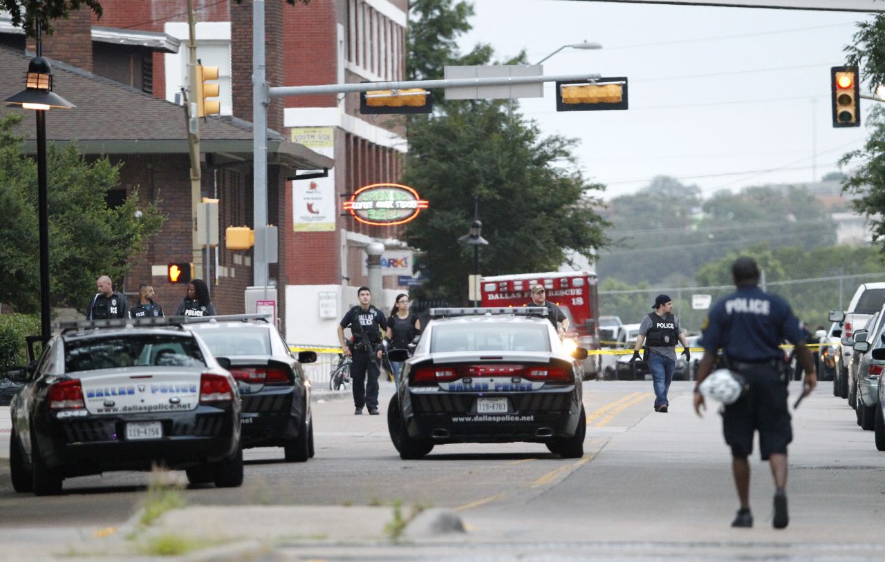 Dallas police officers search Belleview Street near the headquarters. 