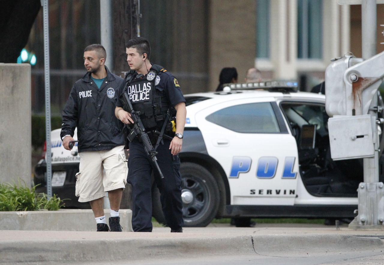 Police officers walk down Belleview Street on June 13, one block away from Dallas Police Department headquarters, as they search the area after the early morning attack on the building.