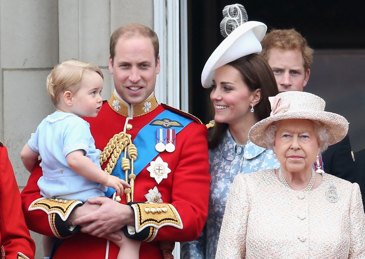 Prince George of Cambridge is held by Prince William, Duke of Cambridge as the family looks on from the balcony of Buckingham Palace.