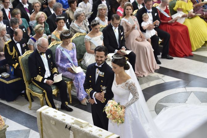 Prince Carl Philip Hellqvist stand at the altar during their wedding in the Royal Palace chapel. In the background are Sweden's King Carl Gustaf, Queen Silvia, Crown Princess Victoria, Prince Daniel and Princess Madeleine.