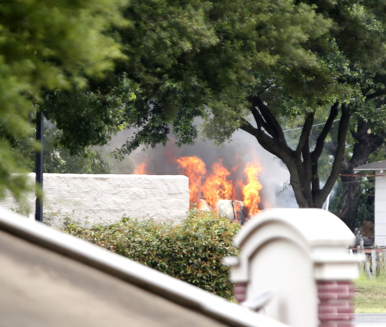 The van used by a lone shooter to attack and then flee Dallas Police Headquarters catches fire outside a fast-food restaurant on June 13,  in Hutchins, Texas. Authorities used controlled charges to discharge pipe bombs in the van after the shooter reportedly unleashed multiple rounds and planted explosive devices around the station before leading police on a chase that ended in a standoff in the parking lot of the restaurant. 