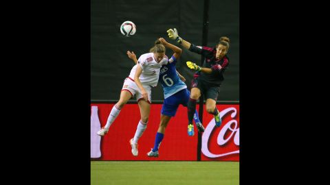 Spain's Celia Jimenez, left, leaps for the ball near Brazil's Tamires and Spanish goalkeeper Ainhoa Tirapu during a match in Montreal on June 13. Brazil defeated Spain 1-0. 