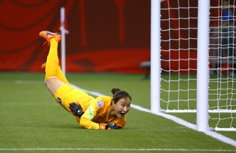 South Korean goalkeeper Kim Jungmi dives as a shot by Costa Rica goes wide of the goal.