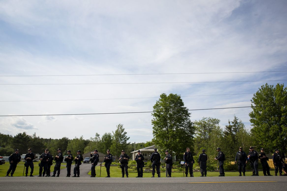 Law enforcement personnel line the roadside on June 13 as they search an area in Cadyville, New York.