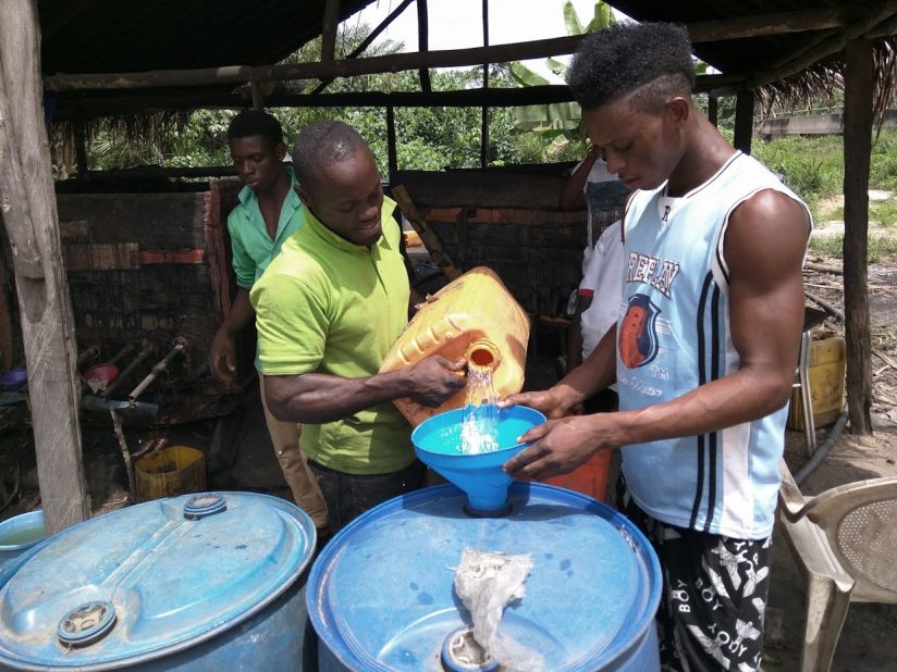 Local gin maker Peter Gabriel fills barrels with distilled gin to be sold locally. The young men say the can make up to 400 liters in a day.