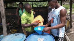 Peter fills barrels with distilled gin to be sold locally. The young men say the can make up to 400 liters in a day.