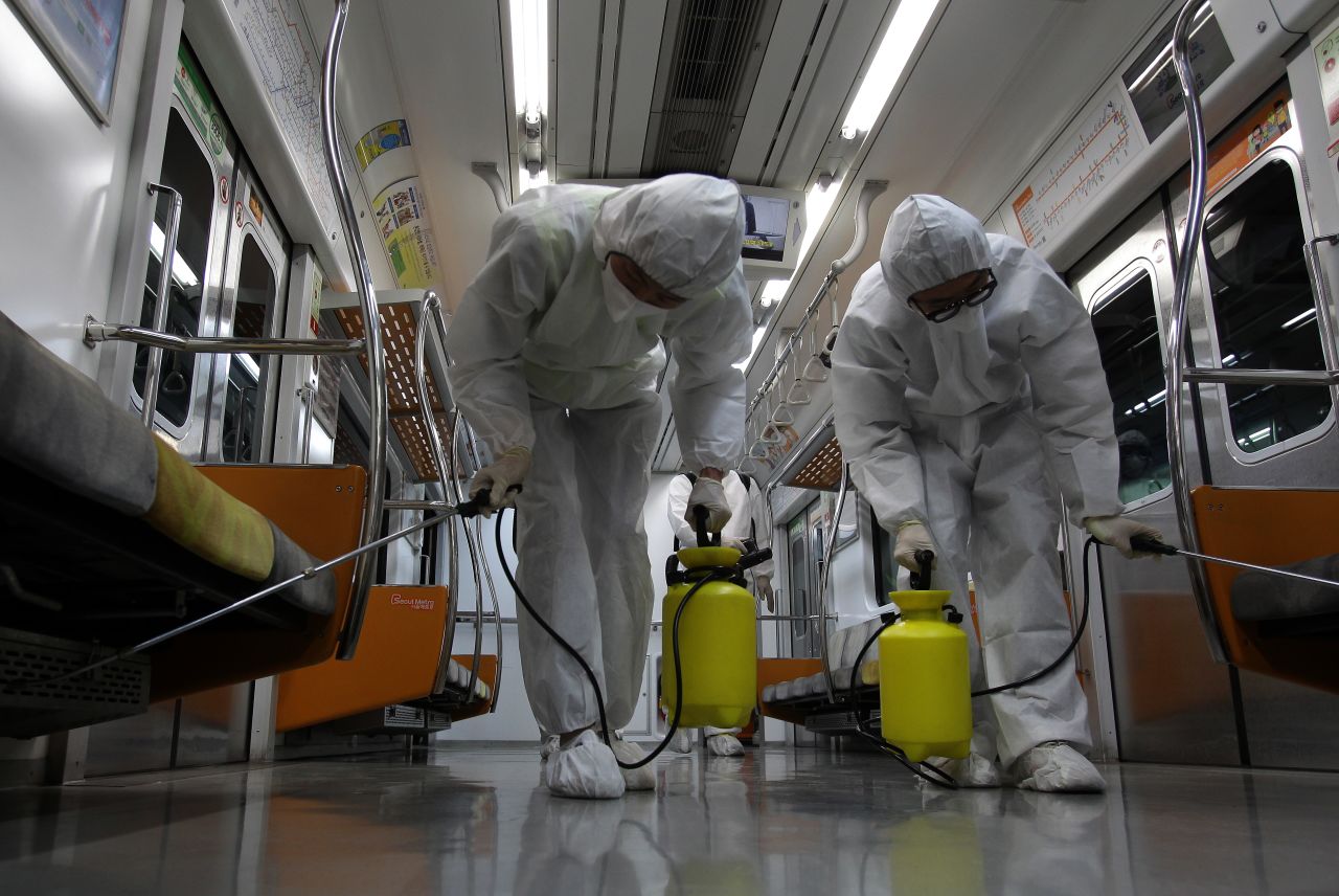 Disinfection workers wearing protective gears spray anti-septic solution in a subway amid rising public concerns over the spread of the MERS virus at Seoul metro railway base on June 9, 2015 in Goyang, South Korea.