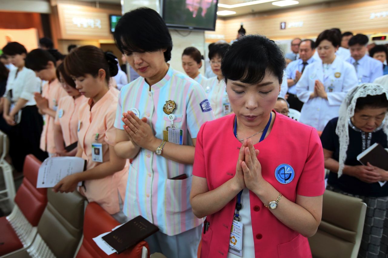 Hospital workers pray as they attend a special service for patients suffering from MERS, at a Sungmo hospital in Seoul, South Korea on Friday, June 12, 2015. 