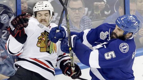 Tampa Bay's Jason Garrison, right, checks Chicago's Andrew Shaw during Game 5 of the NHL Stanley Cup Final. 