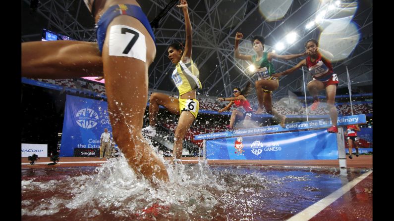 Competitors splash into the water pit during the final of the 3,000-meter steeplechase Friday, June 12, at the Southeast Asian Games.