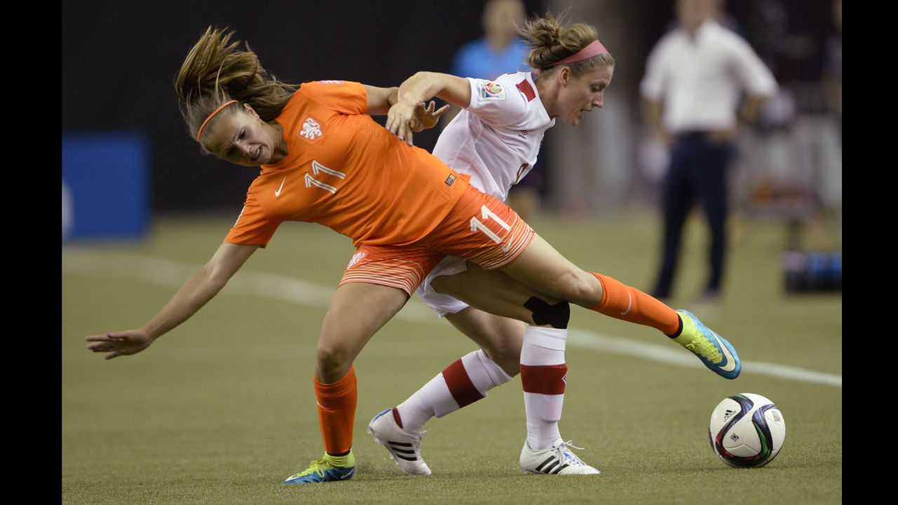 Lieke Martens of the Netherlands and Canada's Josee Belanger compete for the ball. 