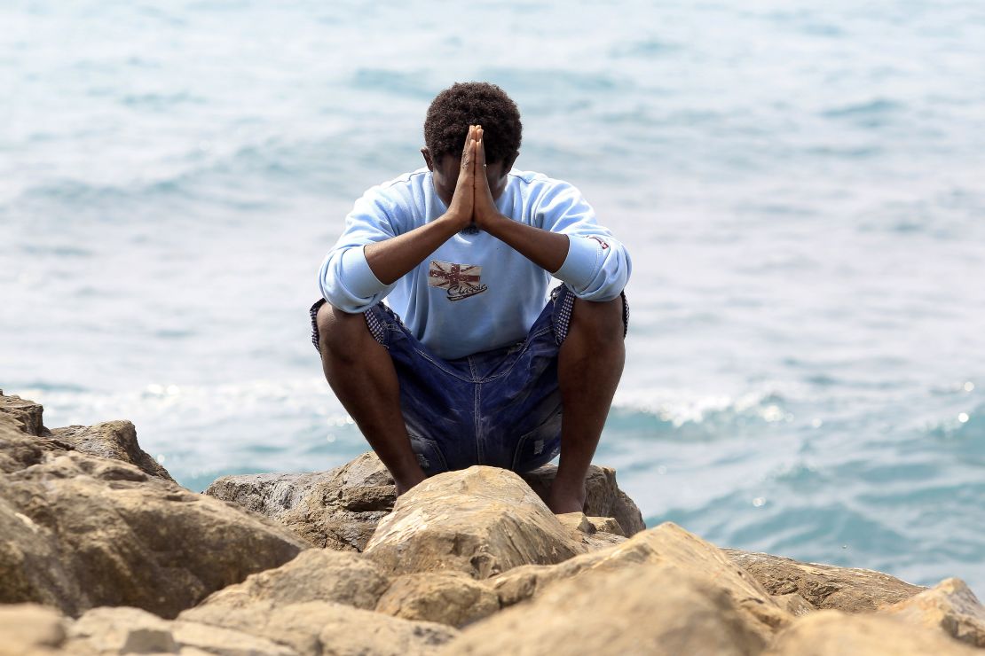 A migrant prays next to the sea in the city of Ventimiglia, Italy.
