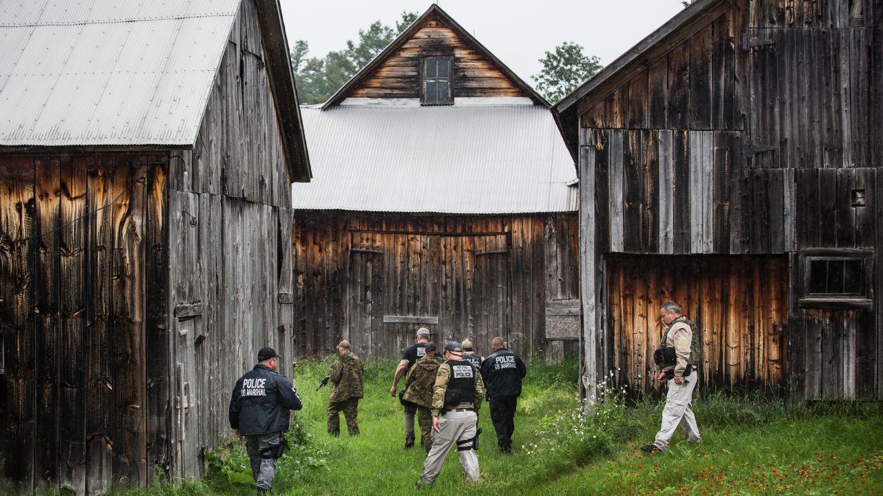 A task force of U.S. Marshals and police officers go door to door near Dannemora, New York, searching for the two escaped murderers on Tuesday, June 16.