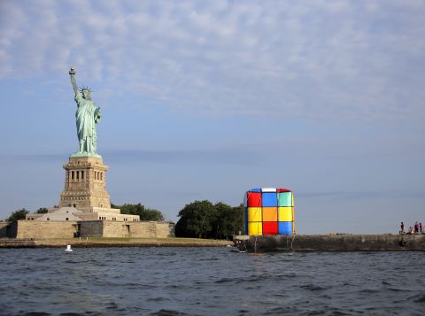 An inflatable Rubik's Cube, en route to a science museum, is transported past the statue in July.