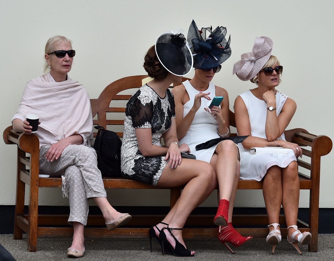 A group of female racegoers gather together to take a break from the action on the turf.